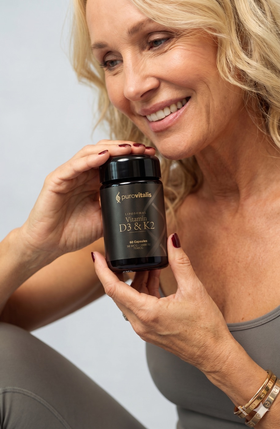 Woman holding a PuroVitalis liposomal Vitamin D3 & K2 supplement